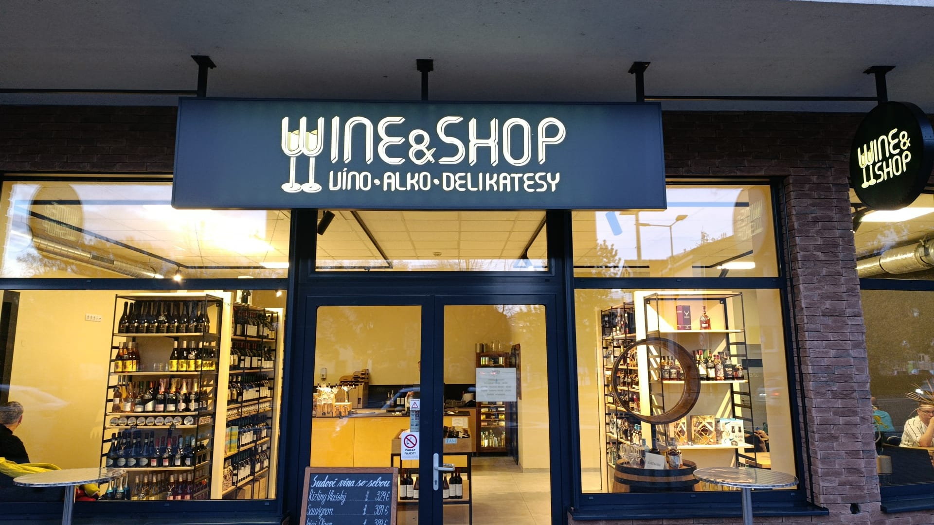 Wine & Shop predajňa večer s rozsvieteným logom